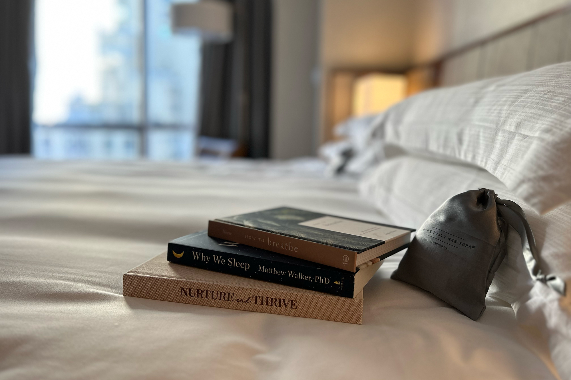 Books and sleep mask bag on the Bryte Bed in the Park Hyatt Restorative Sleep Suite