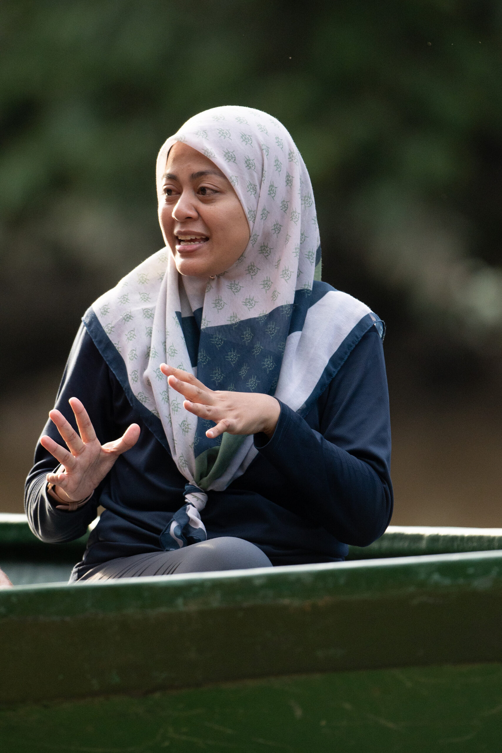 Elephant ecologist in a white head scarf talking into camera