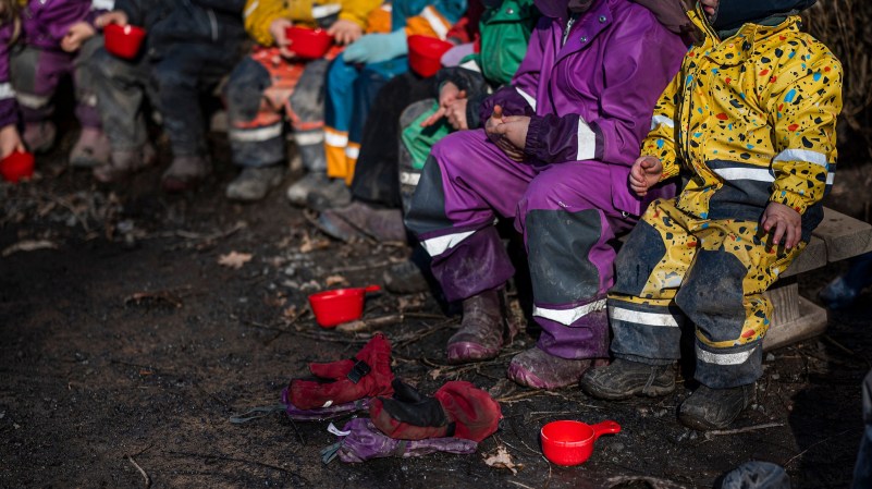 Kids dressed in bright raingear during a forest school class in Sweden