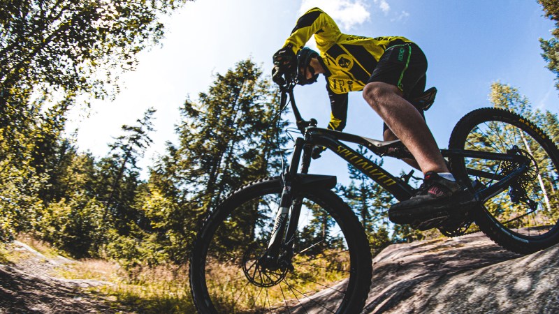 Person rides a mountain bike on an outdoor trail.