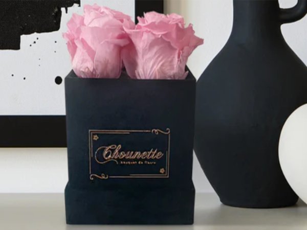 A box of pink roses resting on a table