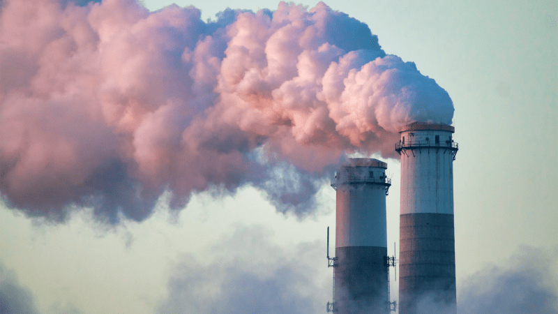 Smoke stacks from a power plant emit smoke.