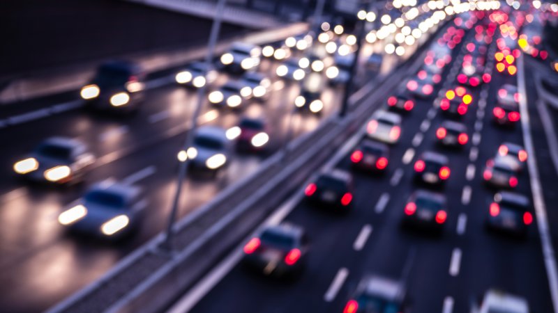 Blurry shot of cars commuting on highway at dusk