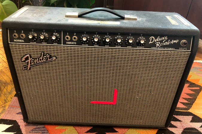  Beat-up Fender Deluxe Reverb guitar amp on a Southwestern carpet