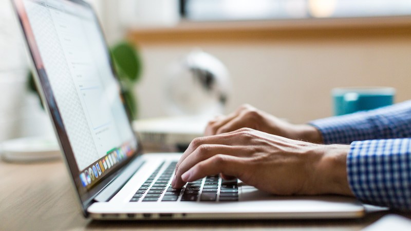 Hands on laptop typing.