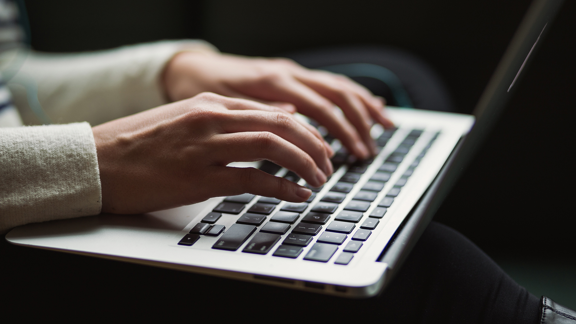 hands typing on laptop keyboard