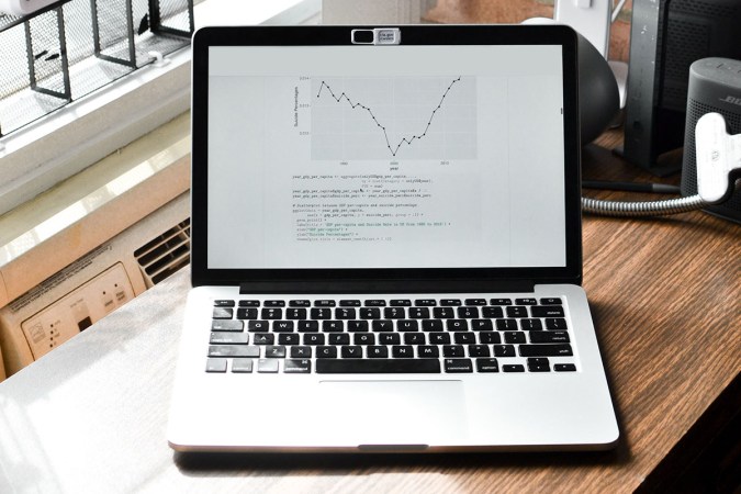 A laptop sitting on a wooden desk.