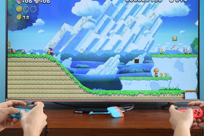 People playing with a Nintendo Switch by connecting it to a television screen