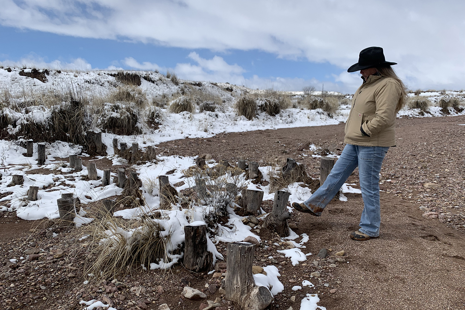 laura norman taps low wooden post with foot