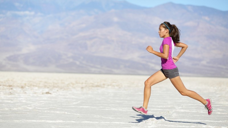 A woman running on a desert trail to burn the most calories.