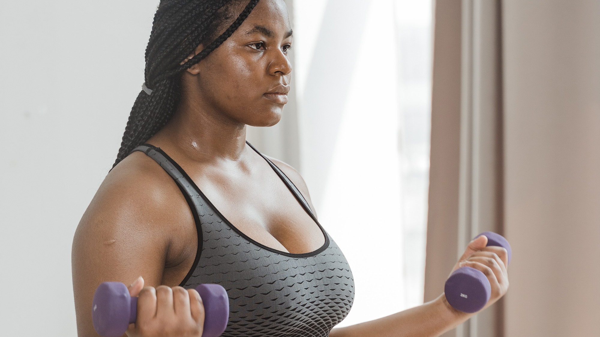 Person working out in living room with dumbbells.