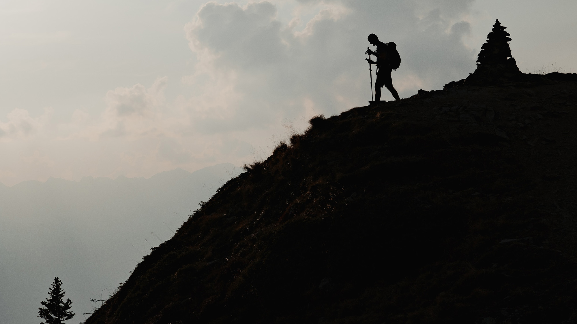 A distant shot of a hiker about to go downhill