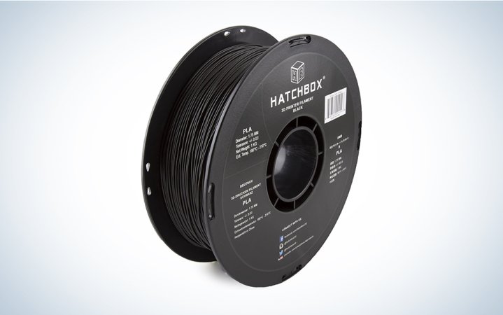  A black spool of Hatchbox 3D printer filament on a blue and white background