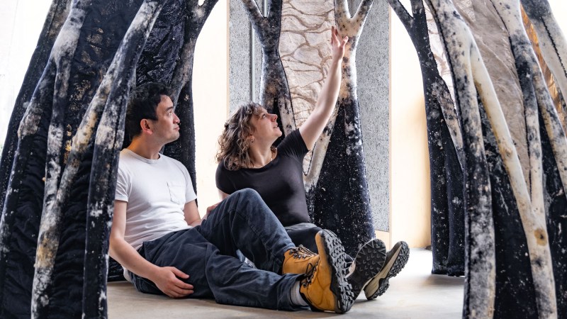 Two people sitting in mycocrete dome structure