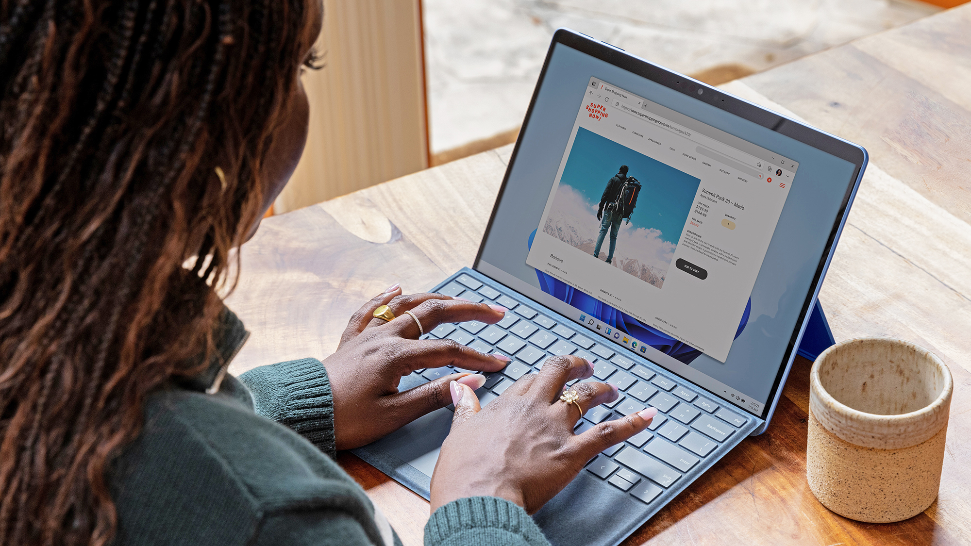 A person using a Macbook laptop with a web browser open on the screen. The more efficiently they use their browser, the longer their battery will last.