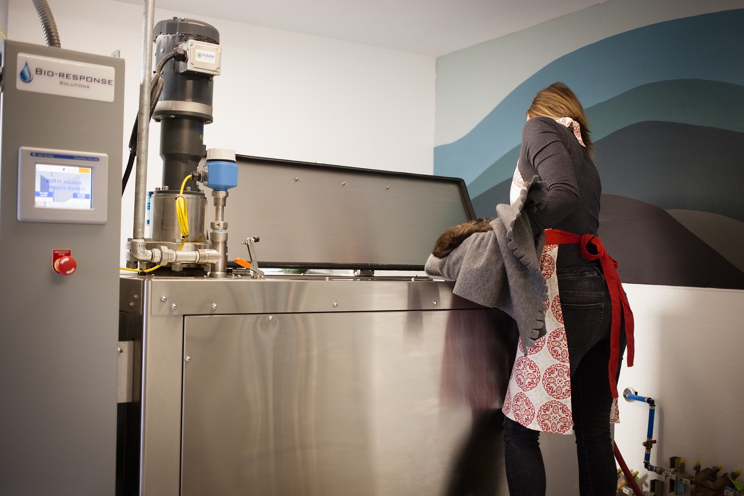 Bio-Response Solutions staff member puts pet remains into an alkaline hydrolysis machine