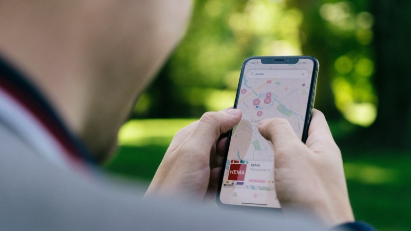 A person using Apple Maps in a park.