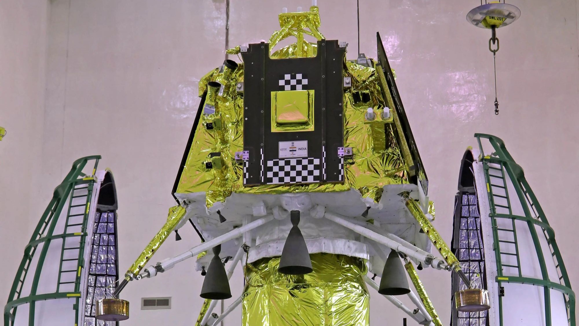 Yellow spacecraft machinery against a white walled background.