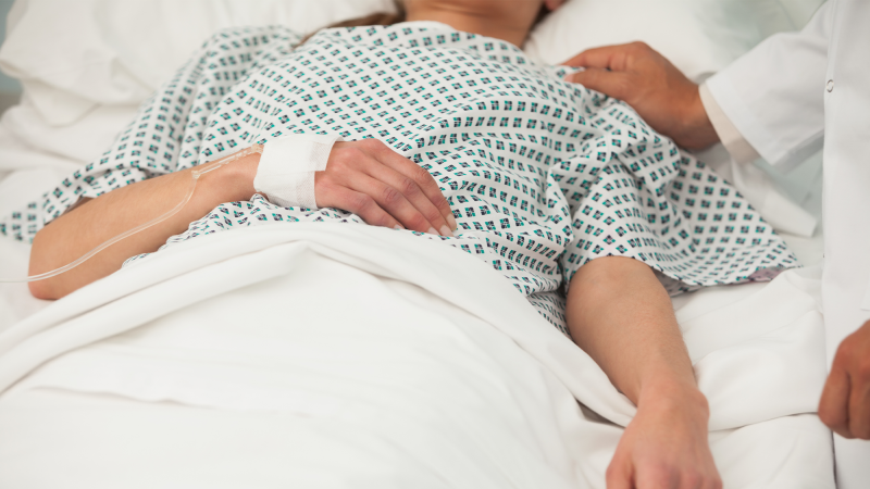 A woman in a hospital, with a doctor touching her shoulder. Some of the health problems associated with long COVID include blood clots, diabetes, heart issues, blood clots, diabetes, neurologic complications, gastrointestinal disorders, fatigue, and difficulties with mental health.