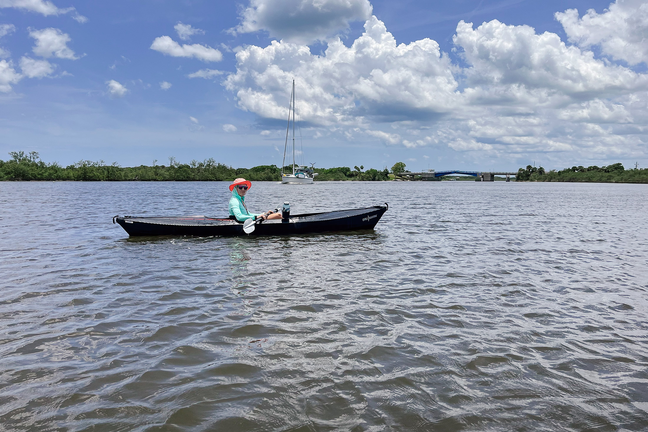 A person sitting in the Oru Beach LT Sport kayak on a river