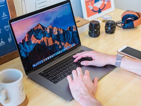 A person sitting at a desk working on a 2017 Macbook Pro