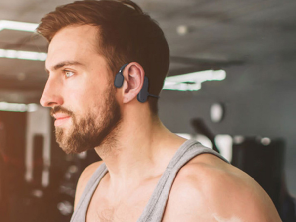 A person working out wearing bone conduction headphones in the gym