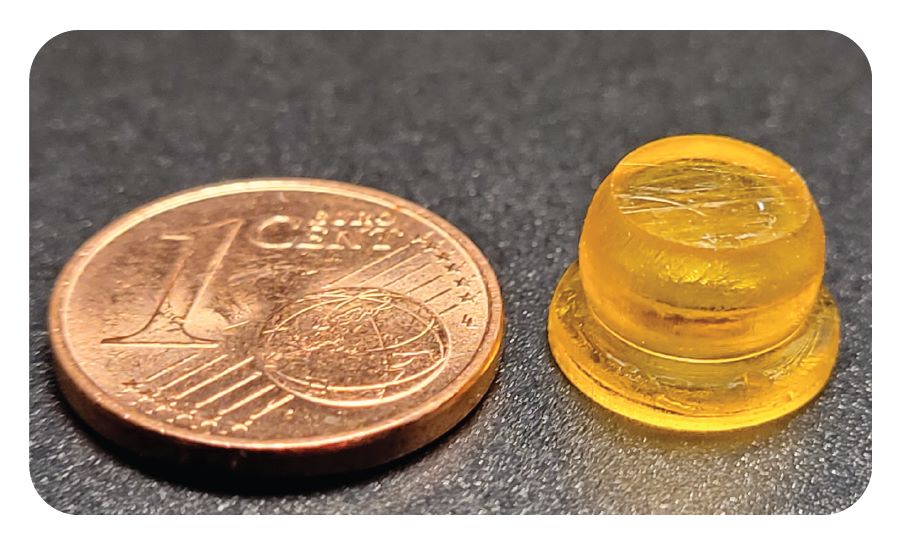 A sucker-shaped drug patch with a 1-cent coin for reference.