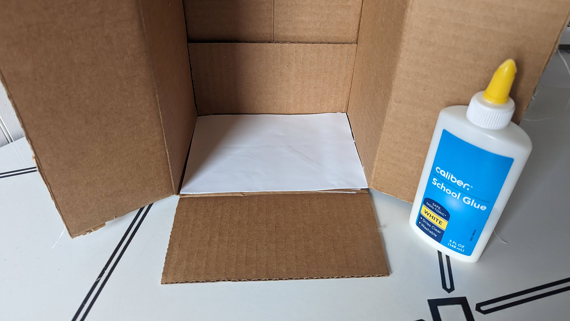 White sheet of paper glued to the inside of a box.