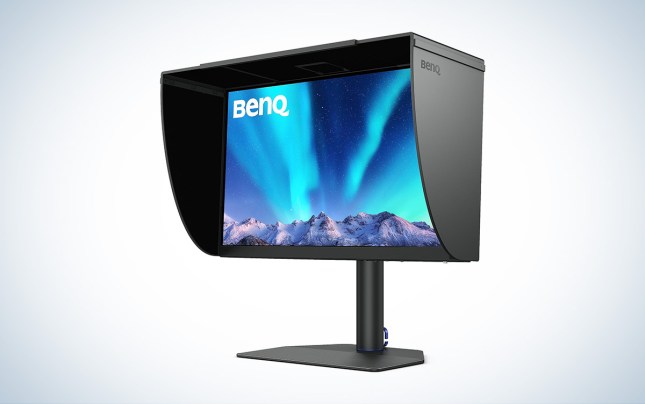 A black BenQ PhotoVue SW272U monitor with a monitor hood against a white background.