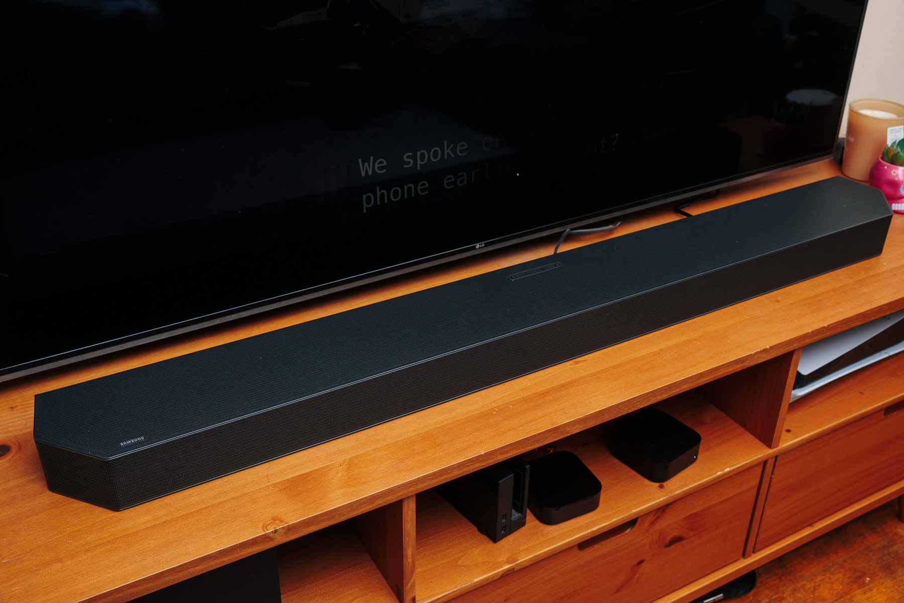 A wide shot of the Samsung Q900C soundbar on a console in front of a TV.