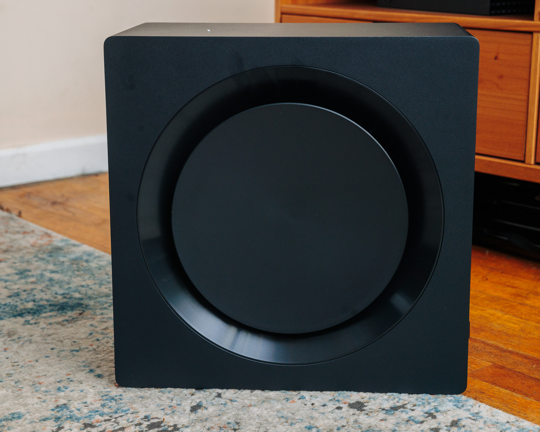 Samsung Q900C wireless subwoofer sitting on a carpet in a living room