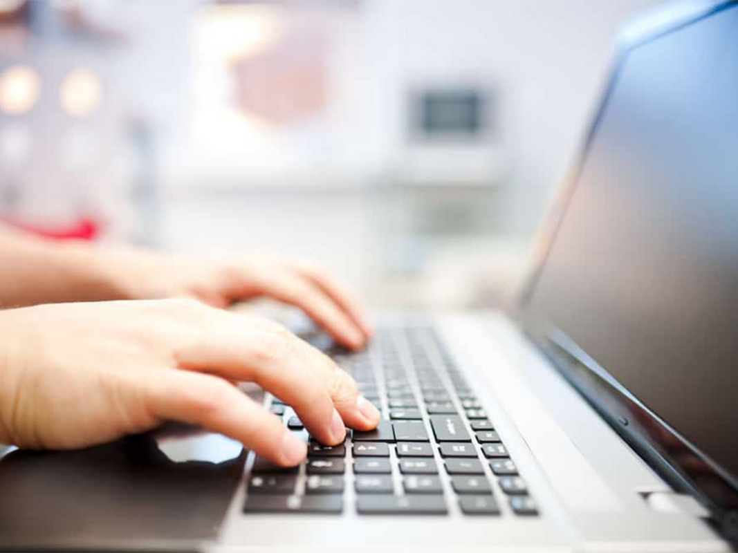 A person typing on a laptop.