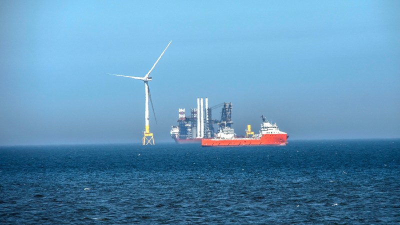 Offshore wind turbine being constructed with nearby supply ship