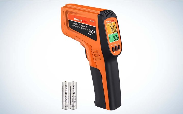  An orange and black ThermoPro TP450 Infrared Thermometer with two batteries against a plain background.