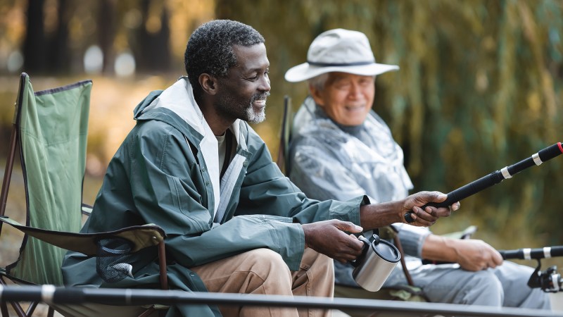 Men making friends and fishing together with thermal cups