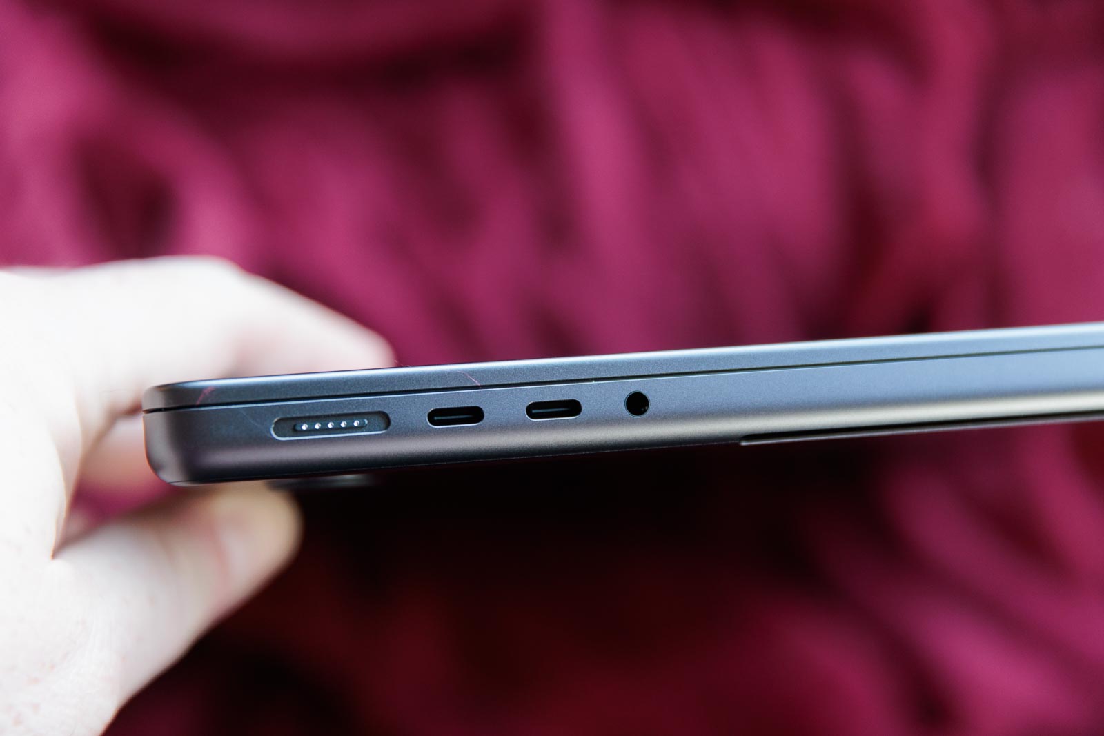 A left side view of the MacBook Pro 14-inch M3 Max on a red blanket