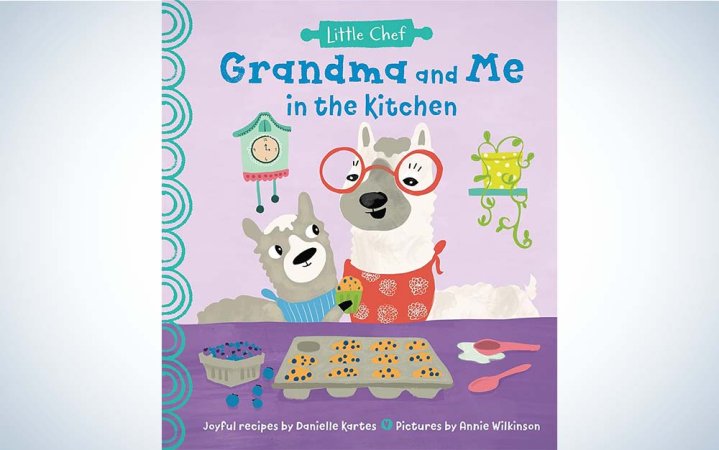  A lavender and purple colored cookbook featuring an older llama and a younger llama making cookies.