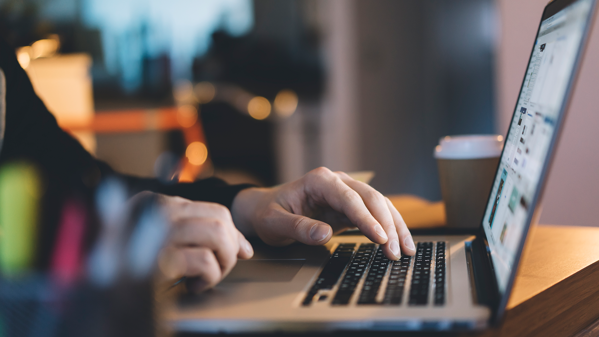 a person's hands typing on a laptop keyboard