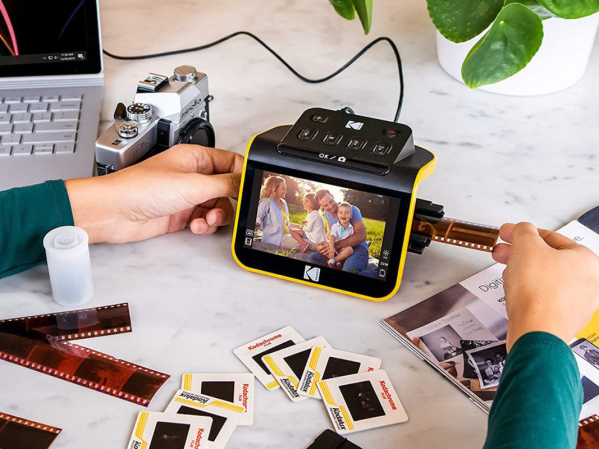 A person using a Kodak a photo scanner and scanning old photos