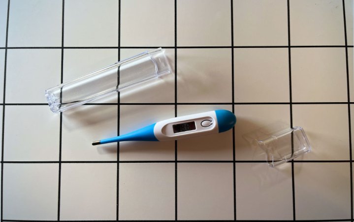  A Boncare digital oral thermometer on a white desk.