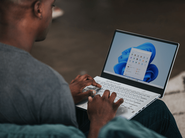 A person typing on a Windows laptop with MS Office booted up.