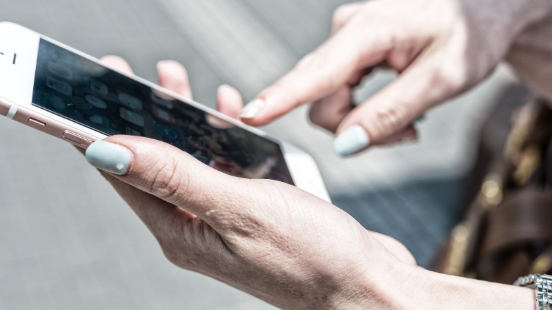 Closeup of woman's hand holding white iPhone