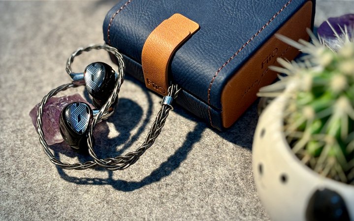  Shiny silver & resin FiiO FA19 in-ear monitors sitting on grey felt with a blue and tan case