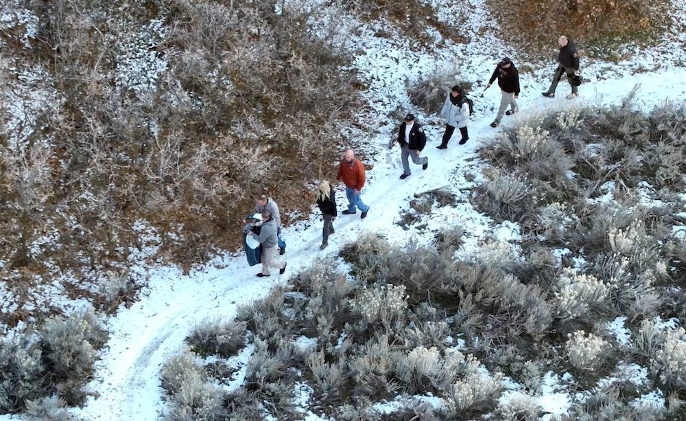 Rescue party escorting cyber kidnapping victim down snowy mountain