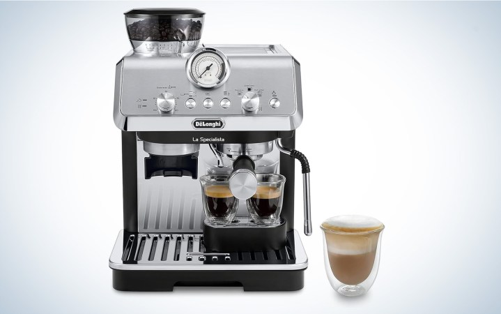  De'Longhi La Specialista espresso machine on a plain background sitting next to a cappucino in a clear mug