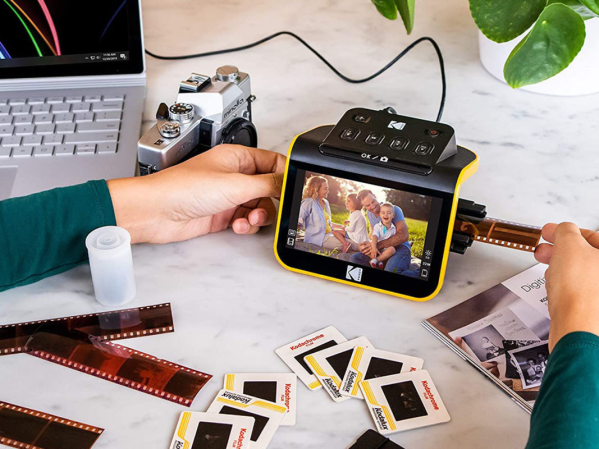 A person using a Kodak Slide N Scan Film & Slide Scanner to scan film.