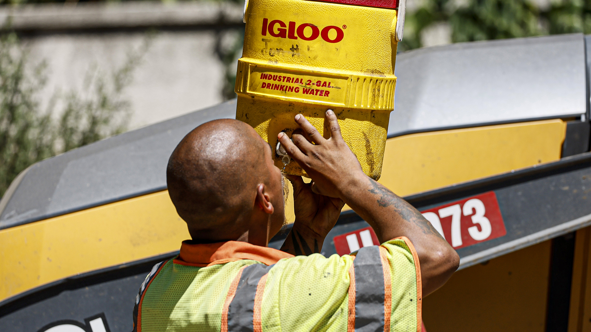 Altadena, CA, Monday, August 28, 2023 - LA County crew member Jonathan Lainez hydrates as he works to repave a section of East Altadena Dr. as temperatures reach 100 degrees and above.