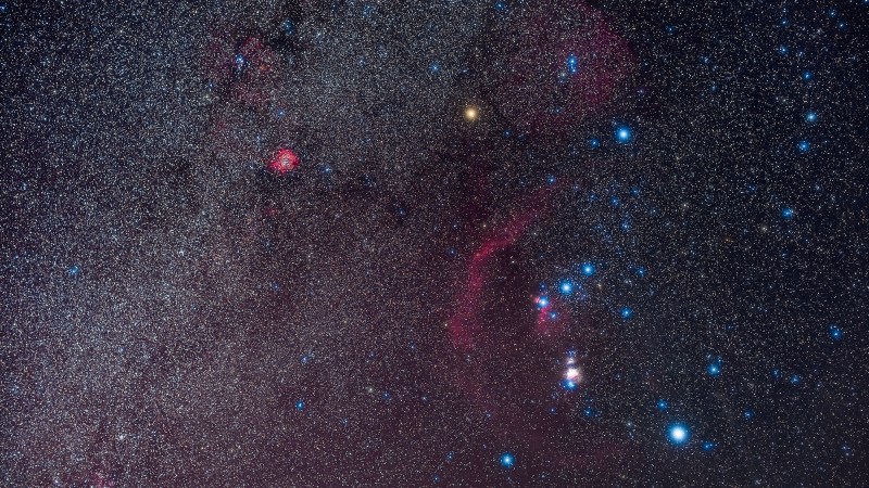 The constellation Orion, the Hunter as seen in the northern winter Milky Way in February 2020. The Orion Nebula is the bright, overexposed pink glow below the Belt of Orion, while the curving arc of red is Barnard’s Loop, now thought to be a supernova remnant. The bright red glow at upper left is the Rosette Nebula. Red Betelgeuse was at its minimum the night this image was taken, at about the same brightness as Bellatrix to the right—Betelgeuse is usually about as bright as blue-white Rigel at the lower right.