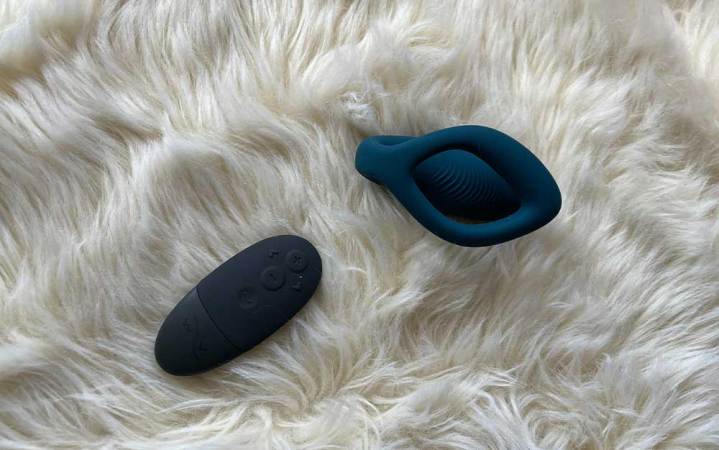  A blue We-Vibe O Sync and remote on a white fuzzy carpet