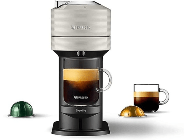 A grey open box Breville Nespresso machine on a plain background.